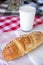 Beef wiener sesame croissant served with a glass of yogurt