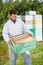 Beekeeper Looking At Honeycomb Crate