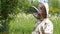 The beekeeper looks at the inoculation of a swarm of bees. A beekeeper in an Australian suit