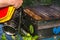 The beekeeper prepares a hive using smoker