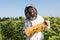 beekeeper in protective suit holding honeycomb