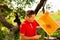 Beekeeper in red t-shirt cuts wax from honeycomb frame with a special knife. Honey production. Close up