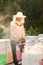 A beekeeper smokes bees in the process of collecting honey in wooden colored beehives. Beekeeping tool