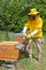 A beekeeper uses a smoker to calm honey bees in the hive