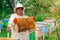 Beekeeper woman controlling beehive and comb frame. Honeycomb. Apiary.