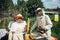 Beekeepers near beehive to ensure health of bee colony or honey harvest. Beekeepers in protective workwear inspecting honeycomb