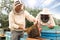 Beekeepers in uniform harvesting honey at apiary