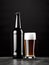 Beer in all its glory, with a beer bottle and a glass filled with the golden brew set against a sleek black background.