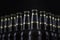 Beer bottles with blank labels lined up in selective focus on black background, one with frost droplets