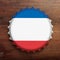 Beer cap with Netherlands flag on wooden background, top view. 3d illustration