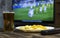 Beer, chips, TV remote control and TV in which show football game