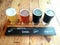 beer flight of light to dark caft beers with a written description of each one sitting on a wooden table