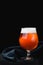 Beer with froth in a glass Snifter isolated on a dark background. isolated glass of beer