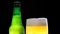 Beer Froth Pouring into a Glass. Cold lager beer. Green beer bottle.