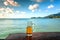 Beer glass on beach bar table past beautiful ocean view. Fresh lager of a tourist under clouds of tropical island