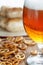 Beer glass pint with pretzels and grilled sausages.