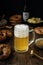 Beer glass with pretzels, bratwurst and snacks on rustic wooden table
