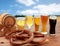 Beer glasses, barrel and pretzel over cereal field