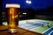 beer half full, illuminated tennis court beyond