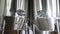 Beer in metal reservoir. Modern beer brewing. Beer factory with stainless tanks for beer fermentation. 4k