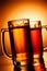 Beer mugs over yellow background