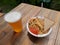 Beer and pilaf with ketchup and bread on the table