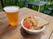 Beer and pilaf with ketchup and bread on the table