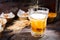 Beer is pouring into a glass near plates with pistachios, small