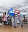 Beer-Sheva, ISRAEL -Clown with blue umbrella, a woman and a white poodle, July 25, 2015