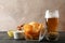 Beer snacks, glass of beer, potato chips, beer nuts, sauces, glass of beer on wooden background