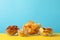 Beer snacks, potato chips, crackers in a bowl on yellow background against blue background