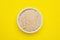 Beer yeast flakes on yellow background, top view