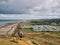 From Beeston Bump a view of the North Norfolk Coast to Cromer. Two walkers and a coast caravan holiday park are visible