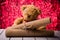 Beeswax candles and teddy bear on nice red background bukeh