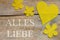 Beeswax, heart and flowers on wooden table, german words, love