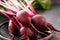 Beet, beetroot bunch on wooden plate on grey stone background. Copy space. .