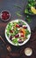 Beet, cheese and orange healthy salad with arugula, lamb lettuce, red onion, walnut and tangerine, brown kitchen table. Fresh