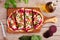 Beet hummus flat bread with feta cheese. Above scene on a paddle board over a wood background.