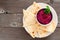 Beet hummus with pita bread on a plate over wood