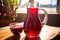 beet juice in a jug with sunlight illuminating through