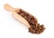 Beet propolis granules in a wooden spoon are on a white background. Natural antibiotic. Beekeeping product