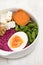 Beet, sweet potato, nuts, green beans and boiled egg in white bowl