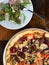 Beet, tomato and pesto pizza and arugula salad with olives