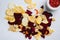 Beetroot carrot and turnip chips, on white stone table background, top view flat lay