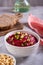 Beetroot hummus in a bowl, bread and chickpeas on the table vertical view