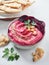 beetroot hummus in a bowl garnished