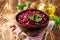 Beetroot salad with wallnuts and garlic in bowl on wooden table