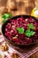 Beetroot salad with wallnuts and garlic in bowl on wooden table