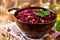 Beetroot salad with wallnuts and garlic in bowl on wooden table