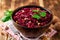 Beetroot salad with wallnuts and garlic in bowl on wooden table